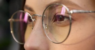 Kahverengi gözlü, gözlüklü, gülümseyen ve kameraya bakan çekici bir kadın. Sağlık ve vizyon için koruma. Doğal kadın güzelliği.