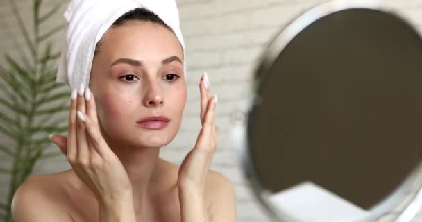Gesunde und junge Frau, die morgens im hellen, modernen Badezimmer ihre Morgenbotschaft zum Liften der Gesichtshaut abgibt. Gesichtsbehandlung am Morgen. — Stockvideo