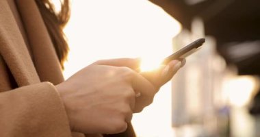 Modern akıllı telefonlarda mesaj yazan kadınların ellerini kapatıyoruz. Çevrimiçi iletişim için aygıt kullanan genç kadın.