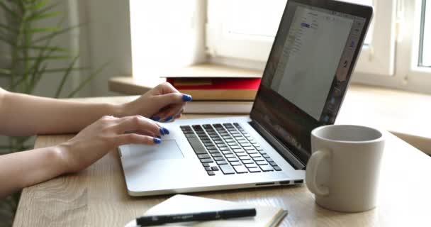Крупним планом молода жінка друкує на клавіатурі ноутбука — стокове відео