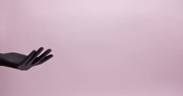 Primo piano di due mani maschili in guanti di gomma medica che condividono con maschera nera su sfondo rosa. Concetto di prevenzione, protezione e malattie infettive. — Video Stock