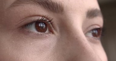 Göz kapakları yanıp sönen güzel kahverengi kadın gözleri. Doğal ciltli bir kadın yüzü. Kirpiklerde hafif rimel. 