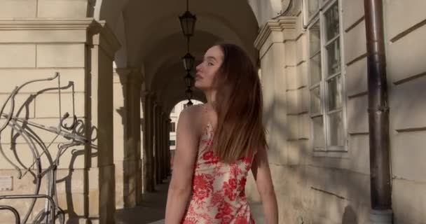 Aantrekkelijke jonge vrouw in de zomer jurk lopen op straat en kijken naar de camera met flirterige blik. Concept van mens, mode en levensstijl. — Stockvideo