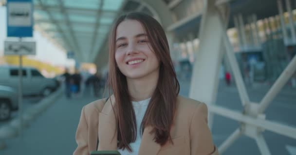 Mulher Adorável Com Cabelo Castanho Usando Smartphone Moderno Enquanto Está — Vídeo de Stock