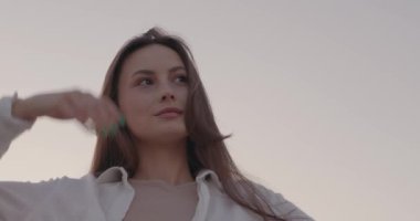 Kaygısız genç bayan gün batımında kırsalda duruyor.