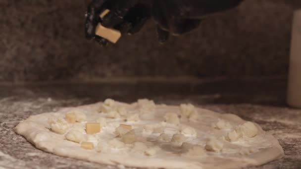 Cerrar las manos masculinas añadiendo trozos de queso duro en la pizza — Vídeos de Stock