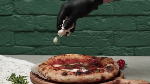 Mężczyzna ręce rozprzestrzenia ser na świeżo pieczone pizza — Wideo stockowe