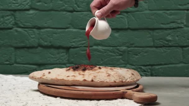 Chef cocinero verter salsa de tomate en pizza al horno — Vídeos de Stock