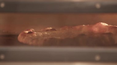 Aşçı sıcak fırından pizza almak için kürek kullanıyor.