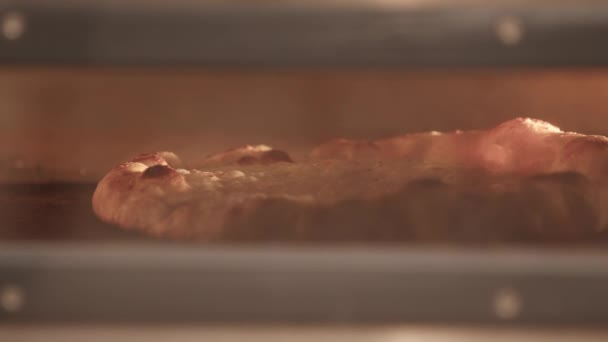シェフは熱いオーブンからピザを取るためにシャベルを使用して料理 — ストック動画