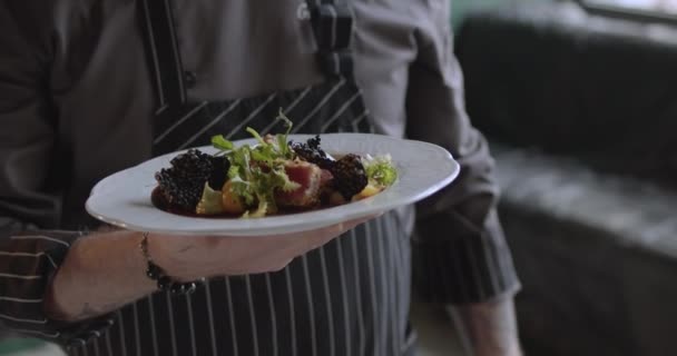 Κοντινό πλάνο του σεφ κρατώντας πιάτο με φρεσκομαγειρεμένη σαλάτα — Αρχείο Βίντεο