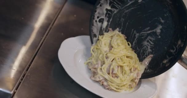 シェフの料理は、フライパンから皿においしいパスタを置く — ストック動画