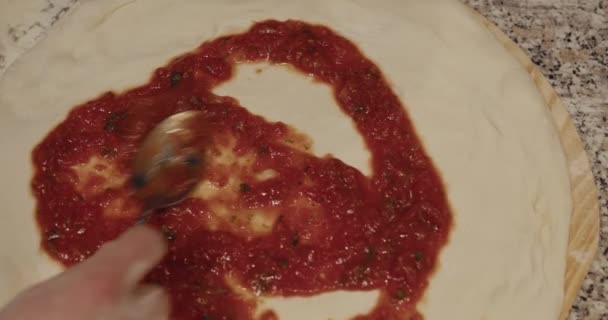 Chef derramando pasta de tomate em massa de pizza crua redonda — Vídeo de Stock