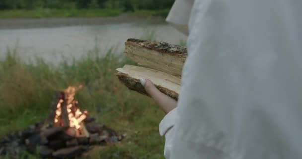 Pelancong perempuan melemparkan kayu ke dalam api — Stok Video