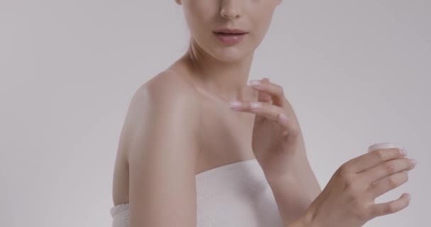 Blanke vrouw die bodylotion gebruikt om de huid glad te strijken — Stockvideo