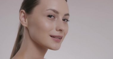 Stüdyoda poz veren pürüzsüz tenli çekici bir kadın.