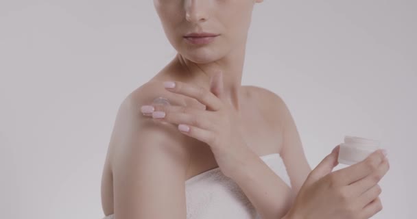 Close up of woman applying cream on naked shoulders — Stock Video