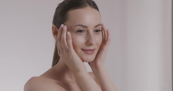 Fantastisk kvinna masserar hennes släta och glänsande ansikte — Stockvideo