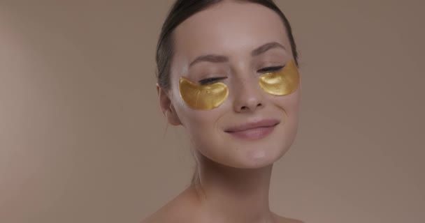 Nádherná žena s kolagen náplastí pod očima ve studiu — Stock video