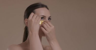 Stüdyoda kolajen göz pedleri kullanan çekici bir kadın.