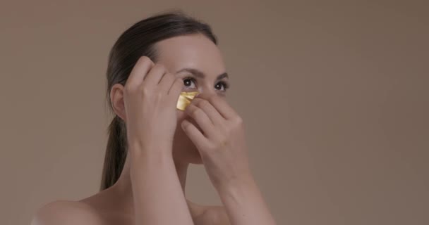 Mulher encantadora usando colágeno olhos almofadas no estúdio — Vídeo de Stock