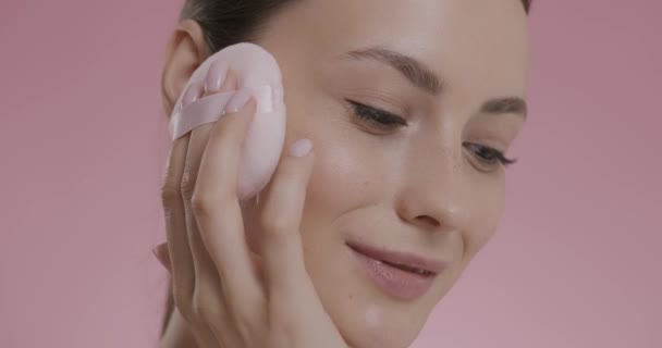 Hermosa dama aplicando polvo ligero en la cara con hojaldre — Vídeo de stock