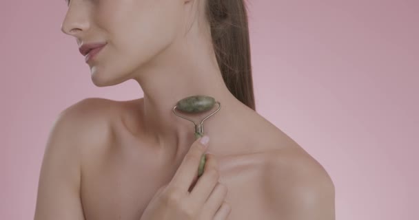 Young woman massaging neck with stone roller — Stock Video