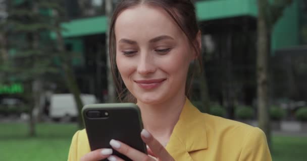 Portrait of business woman using smartphone outdoors — Stock Video