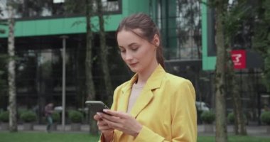 Akıllı telefonlu bir iş kadını dışarıda bekliyor.