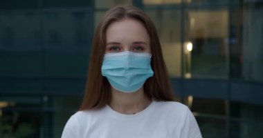 Olumlu kadın dışarıda duruyor ve maskesini çıkarıyor.