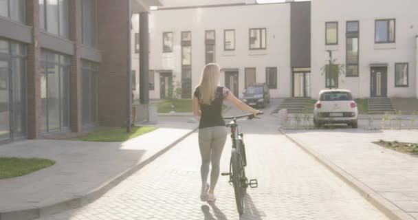 スポーティ女性歩く屋外で黒自転車 — ストック動画