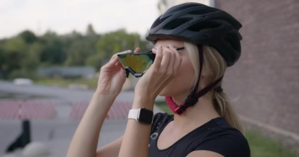 Активная женщина в очках и шлеме для езды на велосипеде — стоковое видео