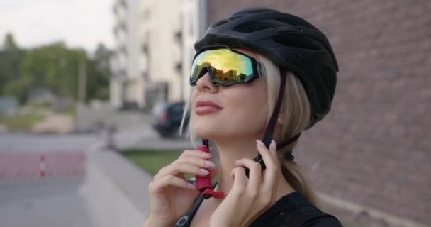 Vrouw met helm en bril om buiten te fietsen — Stockvideo