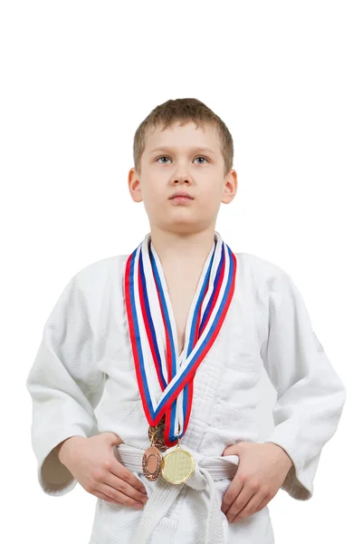 Karate pojke i vit kimono med medaljer kämpar — Stockfoto