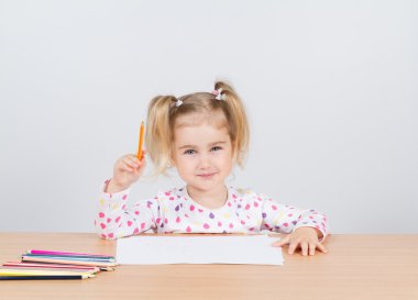 Küçük kız tablo kalemleri çizer.