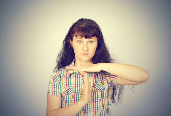 Giovane donna seria mostrando tempo fuori gesto con le mani — Foto Stock
