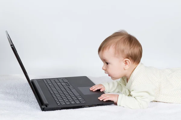 Lindo bebé con portátil negro —  Fotos de Stock