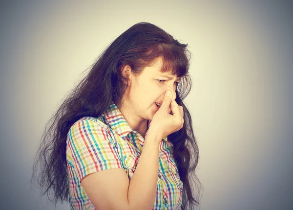 Young woman holding her nose because of bad smell — Stock Photo, Image