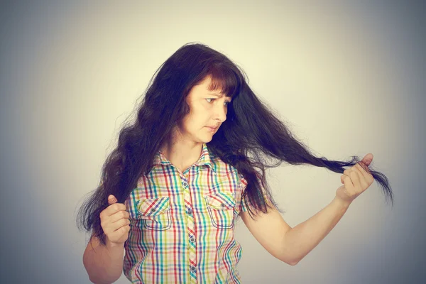 Young woman looks at her problematic hair — Stock Photo, Image