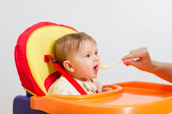 Babyjongen eten met lepel thuis — Stockfoto