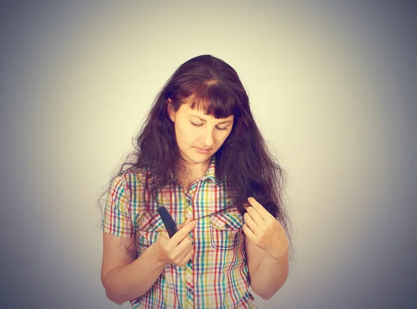 Giovane donna guarda i suoi capelli problematici — Foto Stock
