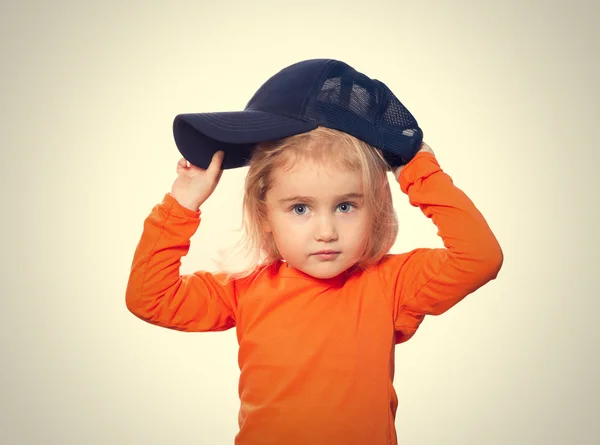 Pequeña chica divertida en gorra de béisbol y blusa naranja — Foto de Stock