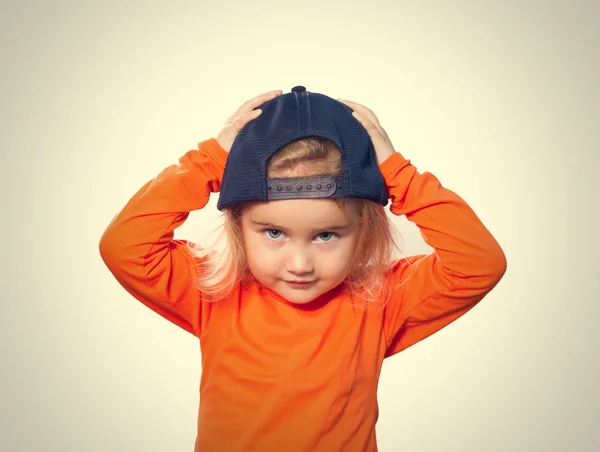Kis vicces lány baseball sapka és narancssárga blúz — Stock Fotó