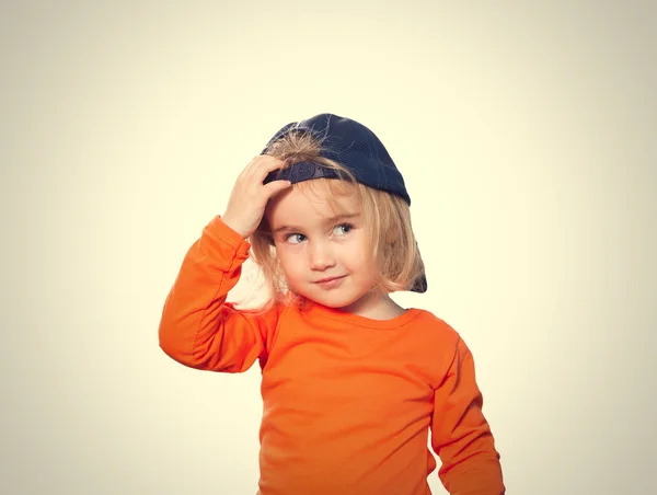 Liten rolig flicka i baseball cap och orange blus — Stockfoto