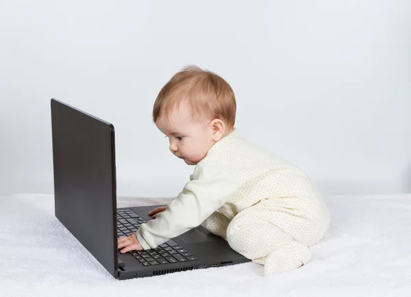 Lindo bebé con portátil negro —  Fotos de Stock