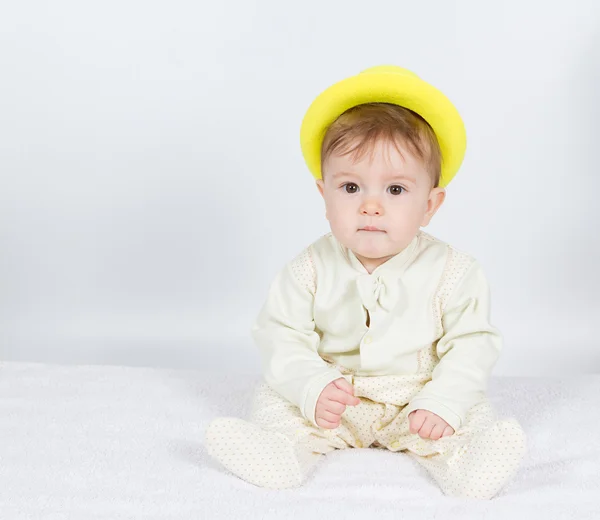 Bebé en el sombrero amarillo se sienta  . — Foto de Stock