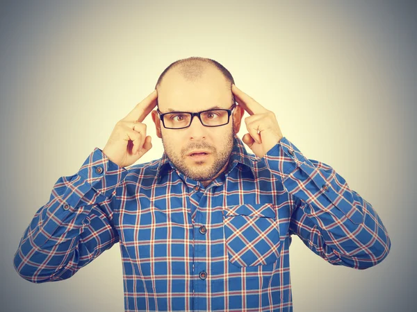 Man met bril zijn hoofd met zijn handen te houden. — Stockfoto