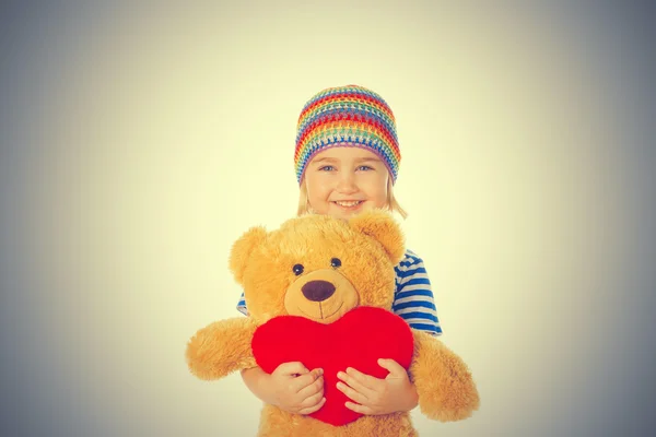 Niña sosteniendo oso de peluche y corazón . —  Fotos de Stock