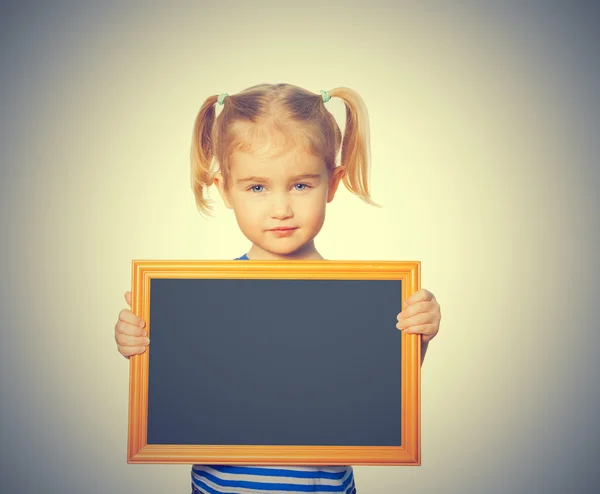 Kleines lustiges Mädchen mit Tafel. — Stockfoto