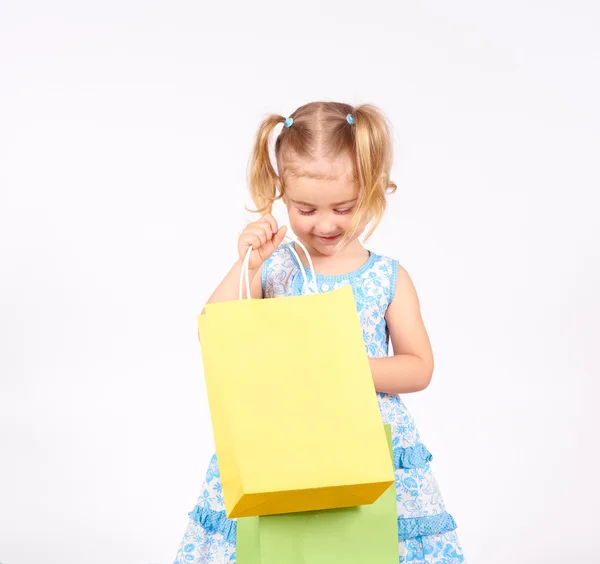 Vásárlás a gyermek. Little girl gazdaság bevásárló táskák — Stock Fotó